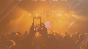 Image of a person recording a concert with their phone, showcasing how social media is often used for entertainment.